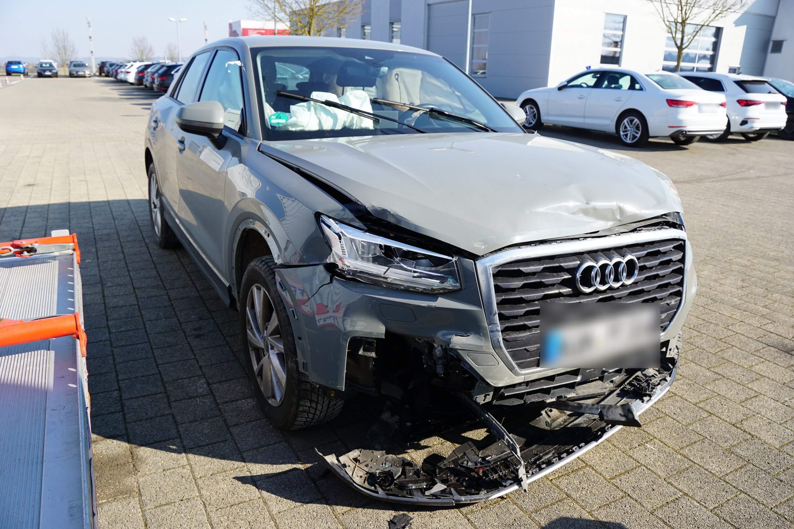 Ein silbergrauer Audi mit stark beschädigter Front steht im Freien, optimal für eine Kfz Gutachten oder Unfallgutachten Bewertung